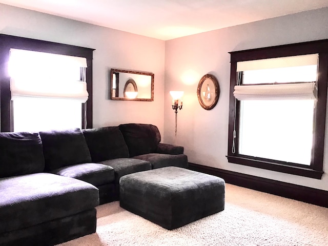carpeted living area with baseboards