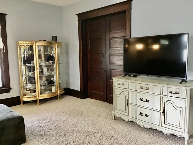 living room featuring light carpet and baseboards