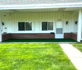 23004 Doremus St Unit 2, Saint Clair Shores, MI 48080 - view of exterior entry with a lawn and board and batten siding