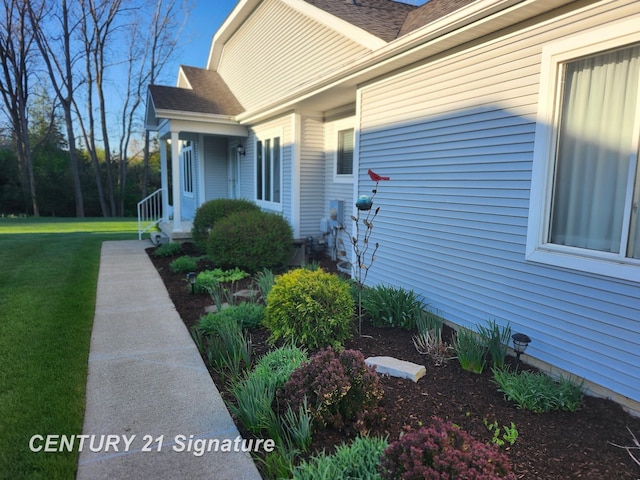 view of property exterior with a lawn and a shingled roof