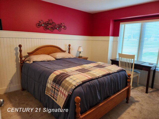 bedroom featuring carpet floors and a wainscoted wall