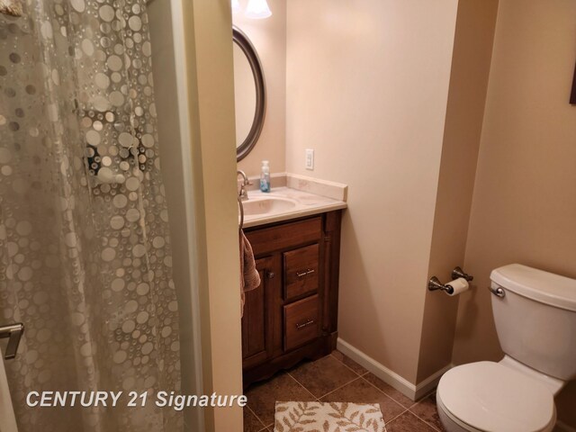 bathroom with tile patterned flooring, toilet, vanity, a shower with curtain, and baseboards