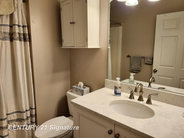 full bathroom featuring toilet, vanity, and a shower with shower curtain
