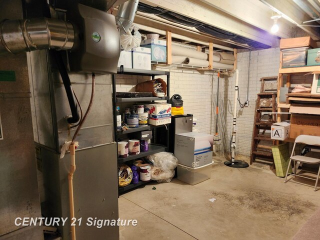 unfinished basement with brick wall and heating unit
