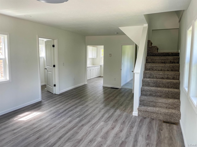 807 N St, Morenci, MI 49256 - unfurnished living room with wood finished floors, plenty of natural light, stairway, and baseboards