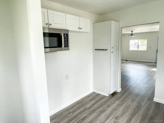 807 N St, Morenci, MI 49256 - kitchen with stainless steel microwave, wood finished floors, white cabinets, and baseboards