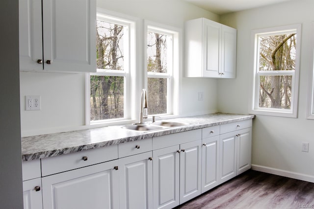 807 N St, Morenci, MI 49256 - kitchen with a sink, light countertops, white cabinets, dark wood-style flooring, and baseboards