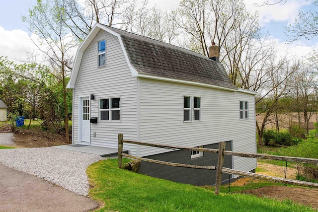 807 N St, Morenci, MI 49256 - view of home's exterior with a shingled roof, a gambrel roof, a chimney, and fence