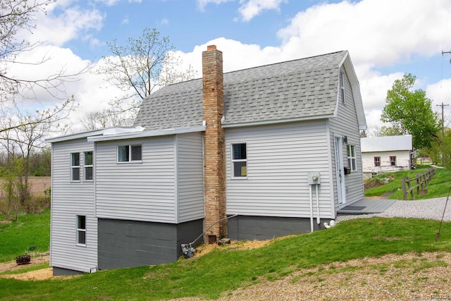 807 N St, Morenci, MI 49256 - back of house featuring roof with shingles, a chimney, and a yard