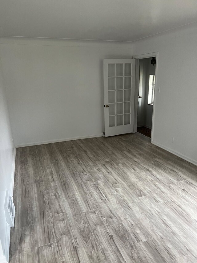 empty room featuring wood finished floors and baseboards