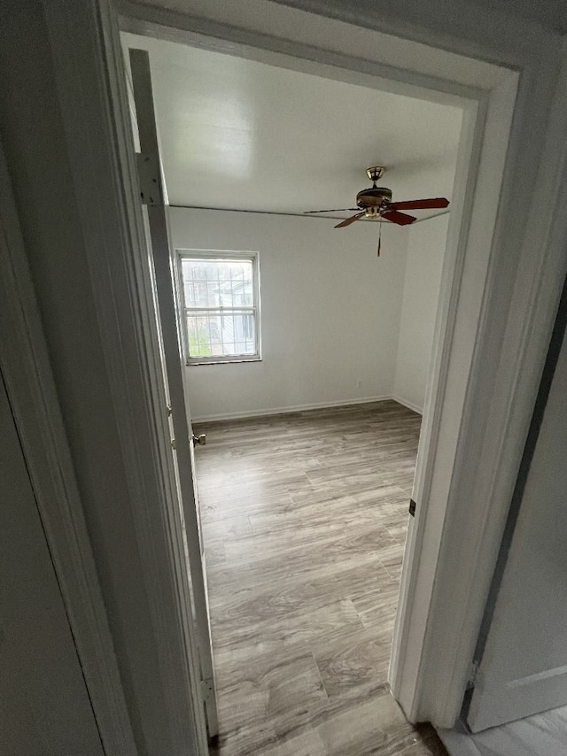 empty room with ceiling fan and baseboards
