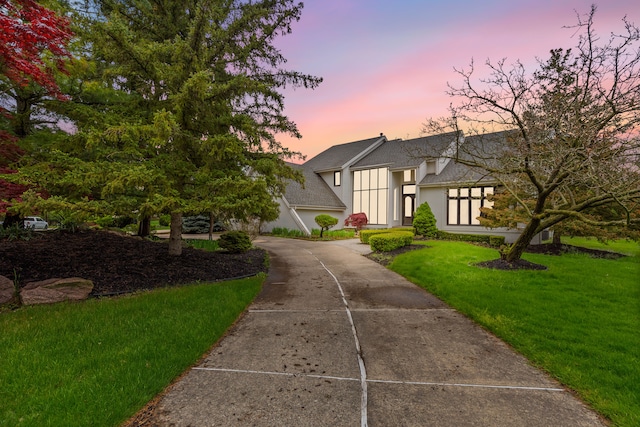 5215 Deer Run Cir, Orchard Lake, MI 48323 - view of front of home with stucco siding, a shingled roof, a front yard, and concrete driveway