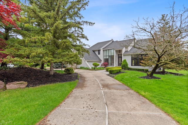 5215 Deer Run Cir, Orchard Lake, MI 48323 - view of front of home featuring roof with shingles, a front yard, stucco siding, and driveway