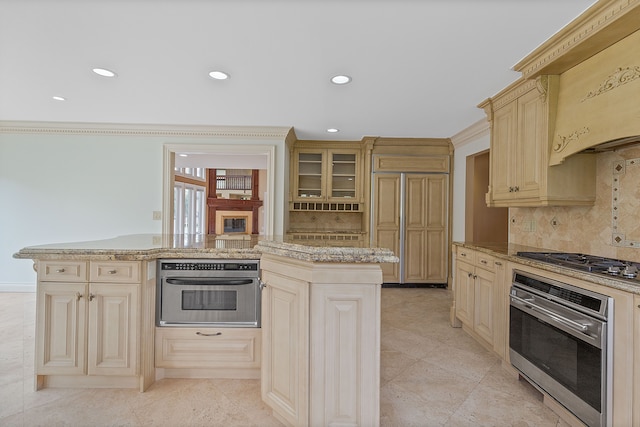 5215 Deer Run Cir, Orchard Lake, MI 48323 - kitchen with stainless steel appliances, decorative backsplash, cream cabinets, recessed lighting, and a center island