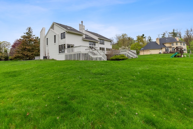 5215 Deer Run Cir, Orchard Lake, MI 48323 - rear view of house with stairway, a playground, a lawn, and a chimney