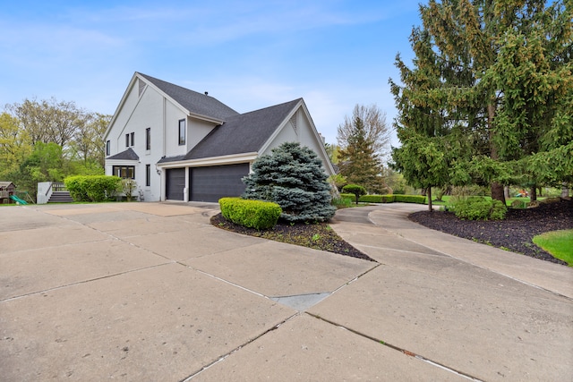 5215 Deer Run Cir, Orchard Lake, MI 48323 - view of side of property with concrete driveway, a garage, and stucco siding
