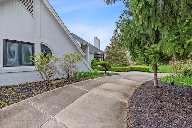 5215 Deer Run Cir, Orchard Lake, MI 48323 - view of property exterior featuring brick siding, a chimney, and concrete driveway