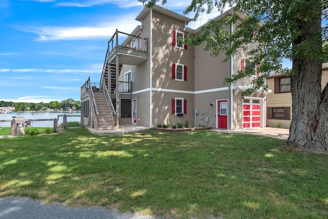 view of front of property featuring stairway, a garage, a water view, and concrete driveway