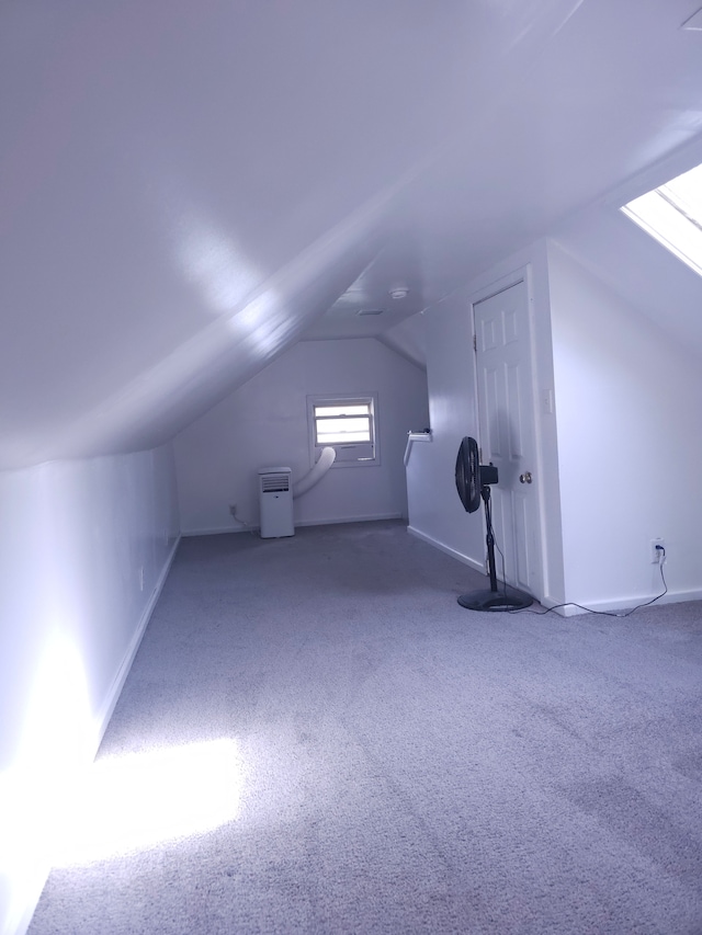 additional living space with carpet flooring, vaulted ceiling, and baseboards