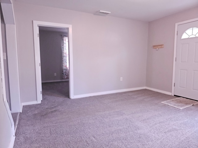 carpeted foyer entrance featuring baseboards