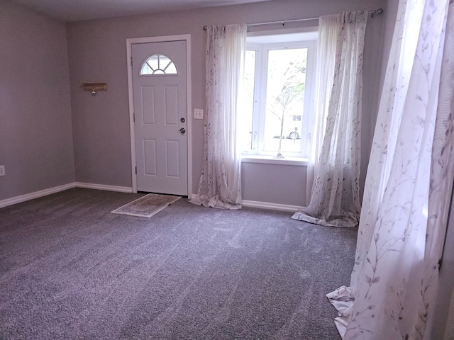 carpeted entryway with plenty of natural light and baseboards