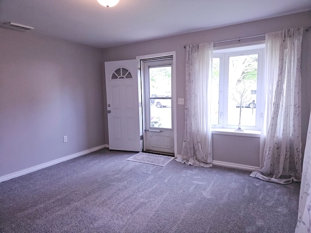 carpeted foyer with baseboards