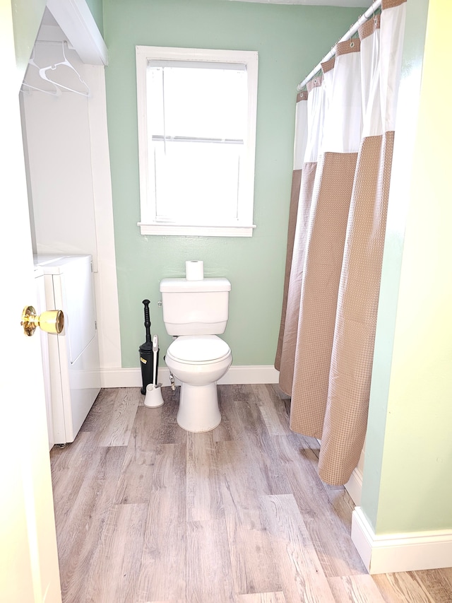 bathroom with baseboards, toilet, wood finished floors, and a shower with curtain