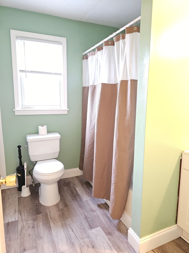 full bath with wood finished floors, toilet, baseboards, and a shower with shower curtain