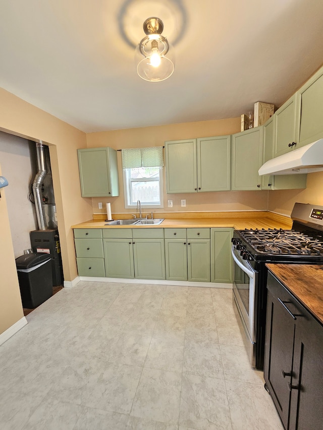 kitchen with green cabinetry, stainless steel gas stove, under cabinet range hood, and a sink