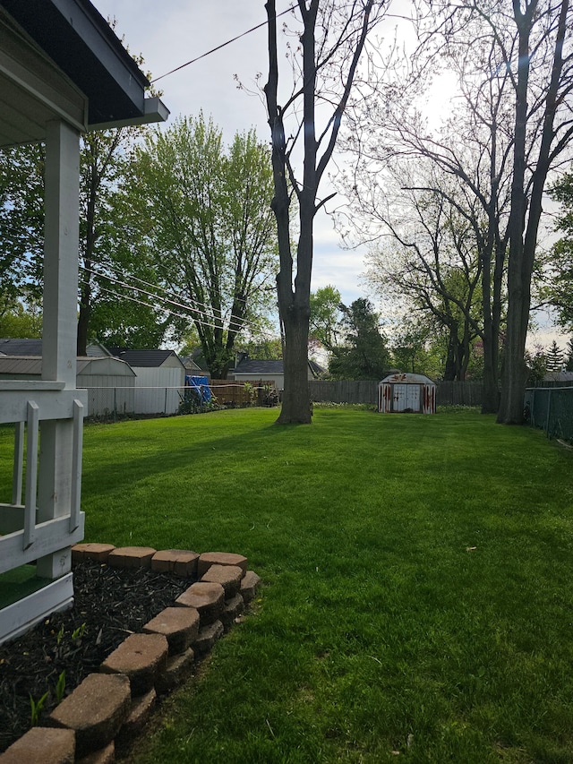 view of yard with a storage shed and an outbuilding