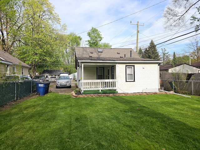 rear view of house featuring covered porch and a shingled roof