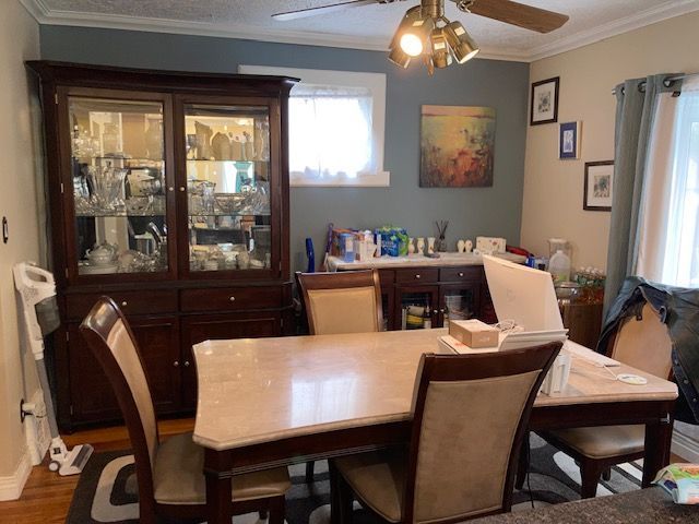 dining space featuring ceiling fan, wood finished floors, and crown molding