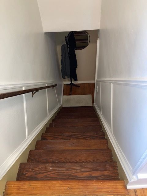 staircase featuring a wainscoted wall