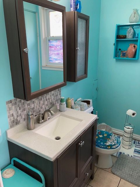bathroom with backsplash, tile patterned flooring, vanity, and toilet