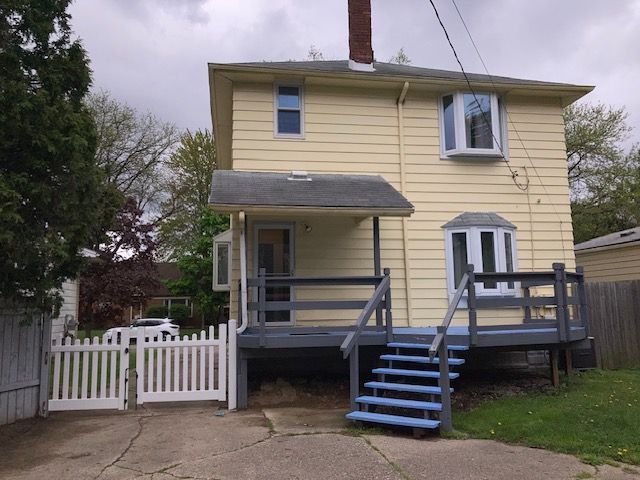 back of house with a chimney, fence, and a wooden deck