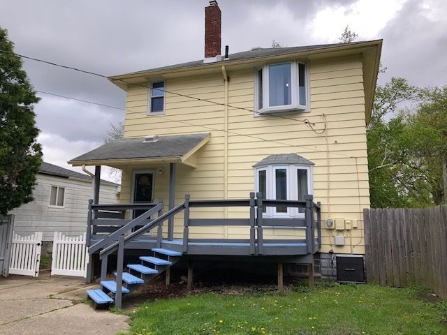 rear view of property with a chimney, fence, a wooden deck, and central AC