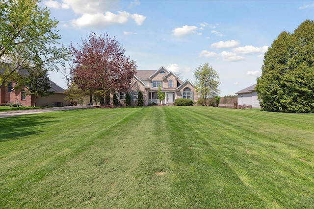 view of front of home with a front yard and stone siding