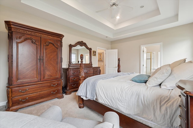 carpeted bedroom with ensuite bath, ceiling fan, recessed lighting, and a raised ceiling