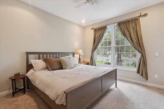 bedroom featuring light carpet, baseboards, and a ceiling fan
