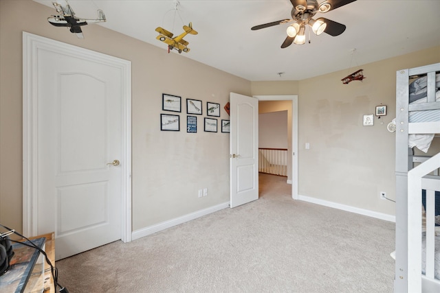 unfurnished bedroom with carpet, baseboards, and a ceiling fan