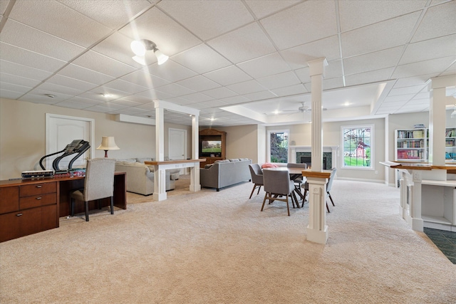 dining space featuring light colored carpet, an office area, ceiling fan, a drop ceiling, and a raised ceiling