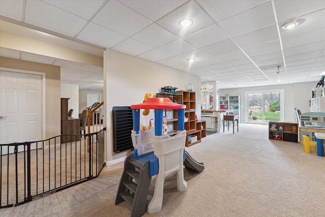 recreation room featuring carpet and a paneled ceiling