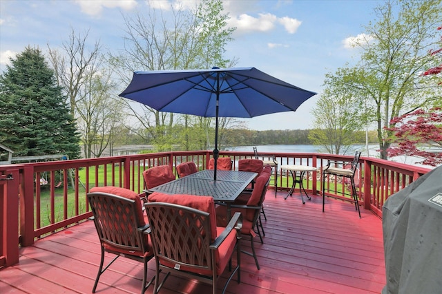 wooden deck with outdoor dining space and a water view