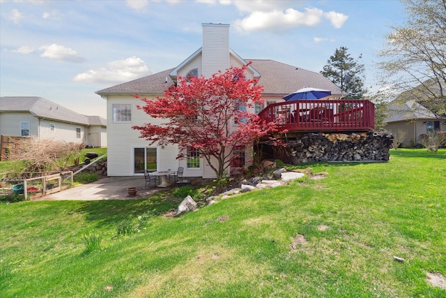 back of property featuring a patio, a wooden deck, and a chimney