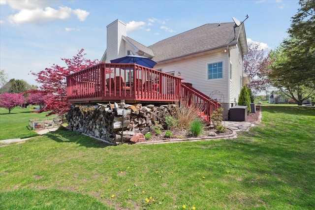 rear view of house featuring a yard, a deck, and stairway