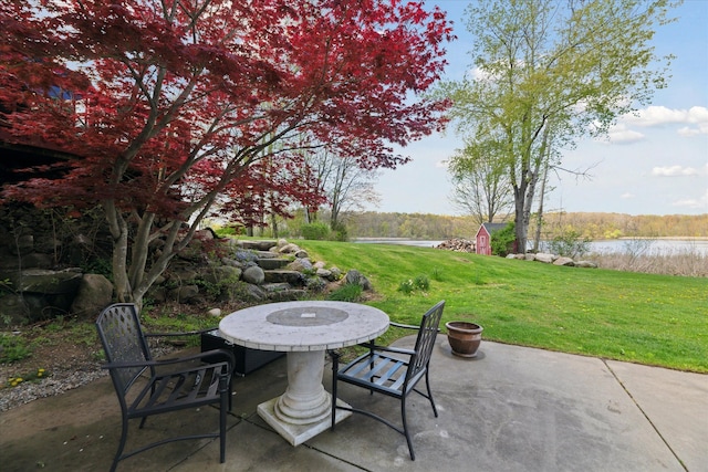 view of patio with a water view and outdoor dining space