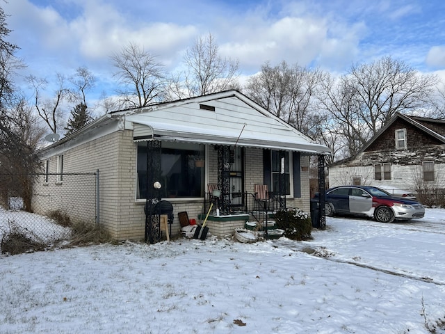 13192 Schoolcraft Rd, Detroit, MI 48227 - shotgun-style home with brick siding, covered porch, and fence