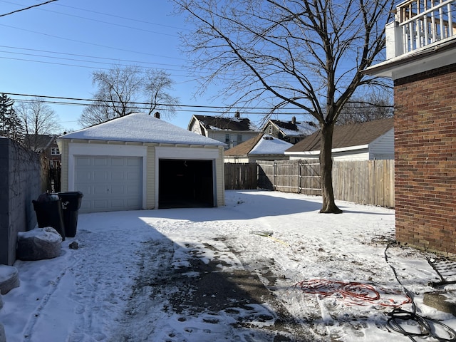 13192 Schoolcraft Rd, Detroit, MI 48227 - snowy yard with a detached garage, fence, and an outbuilding