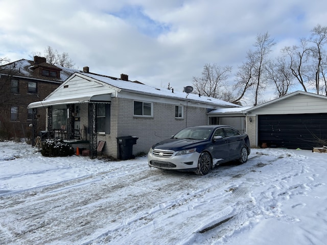 13192 Schoolcraft Rd, Detroit, MI 48227 - view of snow covered exterior featuring brick siding, a detached garage, and a chimney