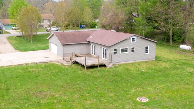 15105 Carpenter Rd, Three Oaks, MI 49128 - back of property with a deck, a shingled roof, a yard, and a detached garage